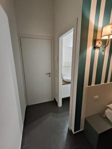 Cette chambre dispose d'une salle de bains avec une porte et un lavabo. dans l'établissement B&B La Piccola Stella, à Salerne