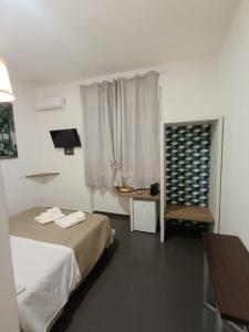 une chambre avec un lit, une table et une fenêtre dans l'établissement B&B La Piccola Stella, à Salerne