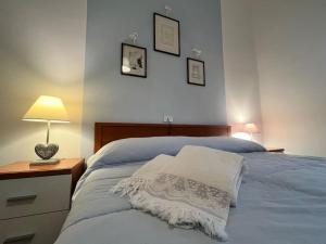 1 dormitorio con 1 cama con lámpara y manta blanca en I sassi della PIAVE, en Barco