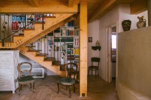 Habitación con escalera con sillas y estante para libros. en B&B Le Tamerici, en San Giorgio di Pesaro