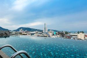 a large swimming pool with a city in the background at The Gig Hotel in Patong Beach