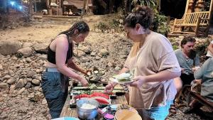考索的住宿－Khaosok August Freedom Camp，一群人站在桌子旁吃着食物