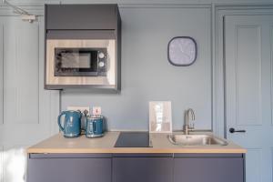 a kitchen with a sink and a microwave at Bluebell Studio Glasgow Airport in Paisley