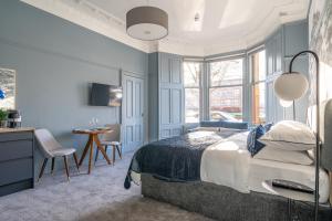 - une chambre avec un lit, une table et des chaises dans l'établissement Bluebell Studio Glasgow Airport, à Paisley