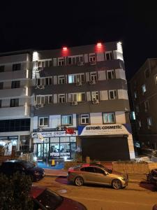 a car parked in front of a building at night at White Crown Apartman ve Yaşam Merkezi in Istanbul
