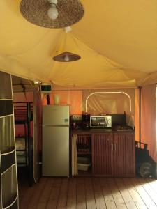 Tienda de campaña con cocina con nevera y microondas. en Tentes canadienne - Camping des trois rivières, en Bassignac