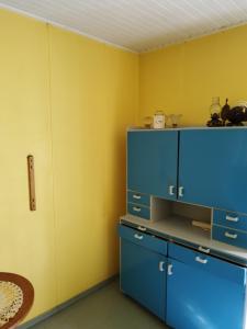 Cette chambre comprend des armoires bleues et une télévision. dans l'établissement Topsala MidIsland, à Houtskari