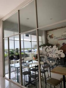 a restaurant with tables and chairs and a large window at Sentul Tower Apartment in Kedungmanggu