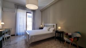 a bedroom with a bed and two chairs and a window at Palermo Politeama rooms in Palermo