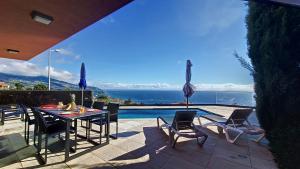 a patio with a table and chairs and a pool at Elísio do Mar by LovelyStay in Prazeres