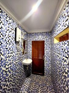 baño con lavabo y azulejos azules y blancos en Kep Villa Hill Guest House 1, en Kep