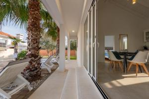 a patio with a palm tree and a table and chairs at Luxury Villa Agape Palm Beach Tennisplatz in Privlaka