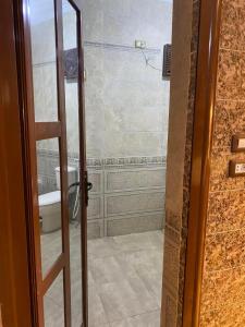 baño con aseo y puerta de cristal en Family House بيت العيلة en El Cairo