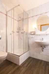a bathroom with a shower and a sink and a toilet at Villa Auszeit Hotel Garni in Bansin