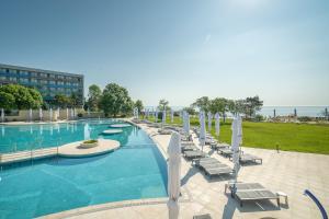 サターンにあるSafir Blue Resortのラウンジチェアとパラソル付きの大型スイミングプール