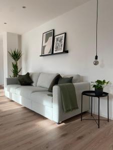 a white living room with a couch and a table at Ferienwohnung Niederbuchner in Chieming