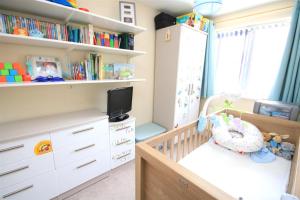 a childs bedroom with a crib and book shelves at No1 Apartment House in Stainforth