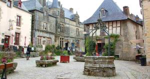 einen Innenhof in einem alten Gebäude mit Leuten, die herumlaufen in der Unterkunft Le Moulin de Gueuzon in Rochefort-en-Terre