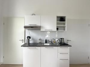 a white kitchen with white cabinets and a sink at Zentrale Zweibettzimmer für Monteure I home2share in Bad Rothenfelde