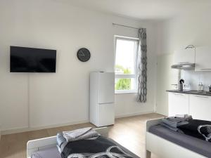 a white living room with a couch and a kitchen at Zentrale Zweibettzimmer für Monteure I home2share in Bad Rothenfelde