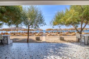 a view of a beach with chairs and umbrellas at Platy Beach Hotel in Platy