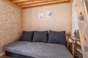 un divano in una camera con muro di mattoni di Charming studio in Old Town Riga a Riga