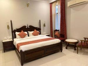 1 dormitorio con 1 cama grande con almohadas rojas en Chitawa Haveli - A Luxury Heritage Hotel en Jaipur