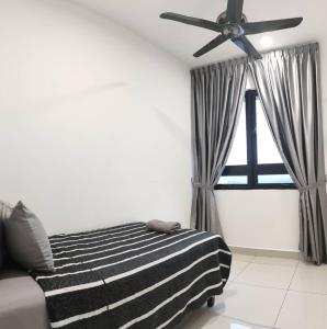 a bedroom with a black and white striped bed and a ceiling fan at MFA Putrajaya Homestay in Putrajaya