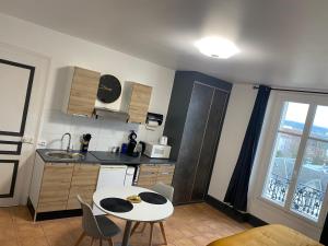 a kitchen with a table and a small table and chairs at Studio Yannick in Vittel