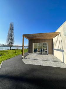 ein Haus mit einem Pavillon vor einem See in der Unterkunft Relais Les Rives du Lac in Coulonges-sur-Sarthe