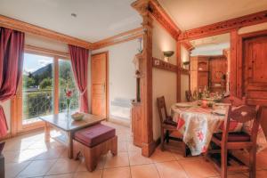 ein Esszimmer mit einem Tisch und einem Fenster in der Unterkunft Résidence Le Cristal Apartments - Happy Rentals in Chamonix-Mont-Blanc