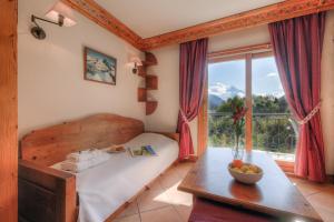 Schlafzimmer mit einem Bett, einem Tisch und einem Fenster in der Unterkunft Résidence Le Cristal Apartments - Happy Rentals in Chamonix-Mont-Blanc