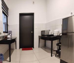 a black door in a kitchen with two counters at MFA Putrajaya Homestay in Putrajaya