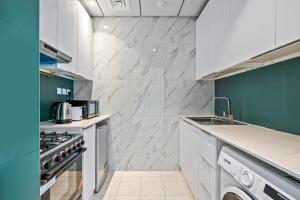 a kitchen with white appliances and green walls at Luxurious Studio - Free Poolgym in Dubai