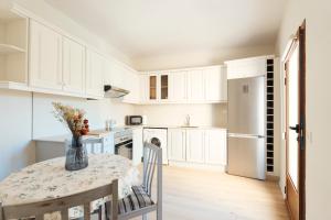 a white kitchen with a table and a refrigerator at Casa Cauma Apartamento in Albarracín