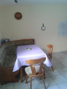 a table with a purple table cloth and two chairs at Apartments zum Brauergang in Garz-Rügen