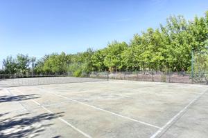 una pista de tenis vacía con árboles en el fondo en La Collina dei Ciliegi en Brufa