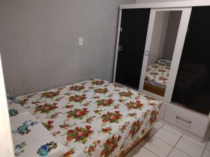 ein Schlafzimmer mit einem Bett mit Blumen darauf in der Unterkunft APTO mobiliado Candeias, JBO/PE in Recife