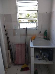 uma pequena casa de banho com um lavatório e uma janela em APTO mobiliado Candeias, JBO/PE no Recife