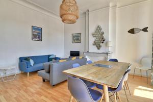 a living room with a wooden table and blue chairs at NOCNOC - Le Minot in Marseille