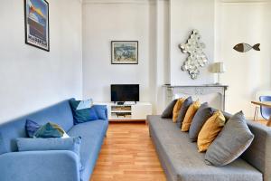 a living room with two blue couches and a television at NOCNOC - Le Minot in Marseille