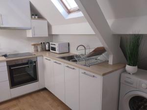 a white kitchen with a sink and a microwave at agréable in Noisy-le-Sec +14 photos
