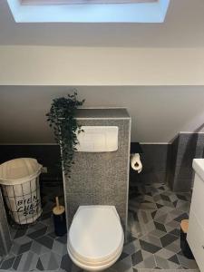 La salle de bains est pourvue de toilettes et d'une plante en pot. dans l'établissement agréable, à Noisy-le-Sec