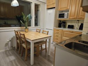 cocina con mesa, sillas y fregadero en Lapinkatu apartments en Rovaniemi