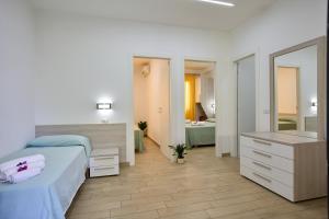 ein Schlafzimmer mit einem Bett und einer Kommode sowie ein Badezimmer in der Unterkunft Villaggio Santa Maria in Capo Vaticano