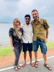 a group of three people standing next to the water at Jm Resort in Dambulla