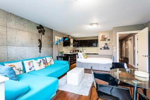 a living room with a blue couch and a glass table at Modern 2-Bed Flat Bethnal Green in London