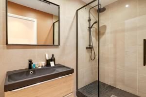 y baño con lavabo y ducha. en 220 Suite Jessy - Superb Apartment in Paris, en París