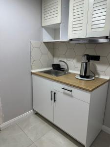 a small kitchen with white cabinets and a sink at Tiny 1 in Istanbul