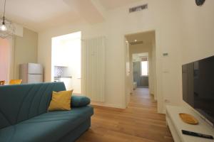 ein Wohnzimmer mit einem blauen Sofa und einem TV in der Unterkunft Case VR Holiday Aurora in Verona in Verona